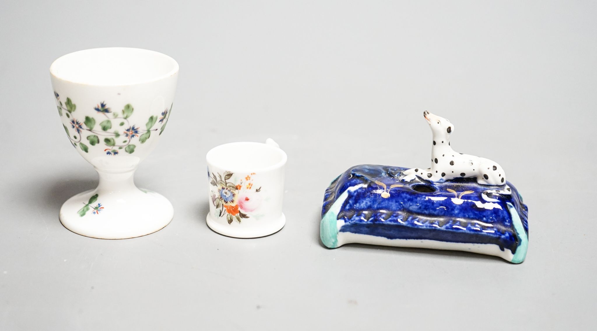 A mid 19th century Staffordshire porcelain Dalmatian pen holder and a cornflower spray egg cup and a miniature mug, tallest 6cm